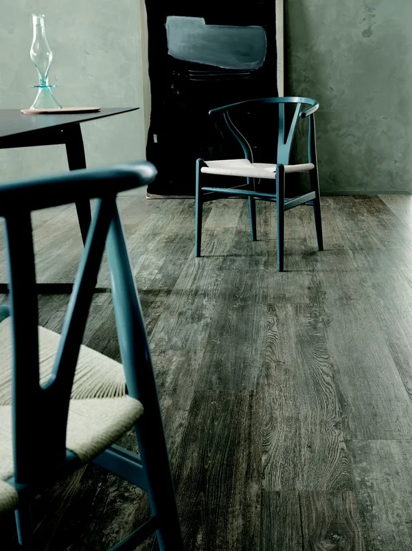 Helles Esszimmer mit dunkelbraunen Holzoptikfliesen und großem Esstisch