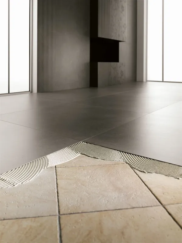 Detailaufnahme der Verlegung von großformatigen Fliesen mit Fliesenkleber