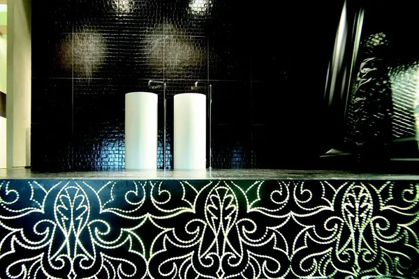 Designbadezimmer mit schwarzen Wandfliesen und modernem Waschtisch